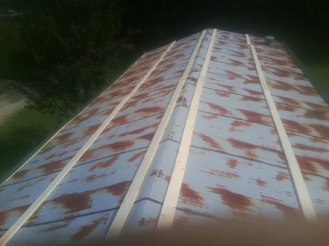Rusted metal roof panels with new wood purlins before replacement — Storm Damage Roof Repair in Portage by Roofing Brothers